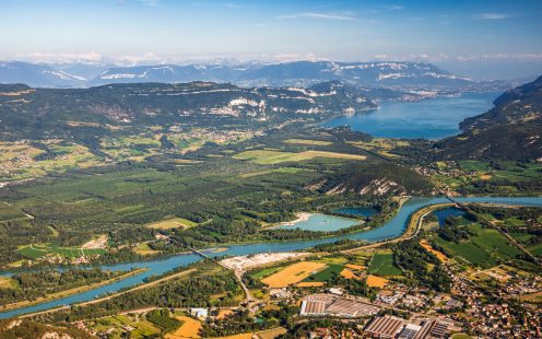 Vibrant color photography of beautiful aerial view French landscape viewed from Grand Colombier summit in middle of Bugey mountains, with Rhone river, vibrant green fields and Lake Bourget in Savoie. Shot from Grand Colombier mountain summit during a sunny summer day, in Bugey mountains, in Ain department not far from Jura and Savoie border near Culoz city, Auvergne-Rhone-Alpes region in France (Europe).