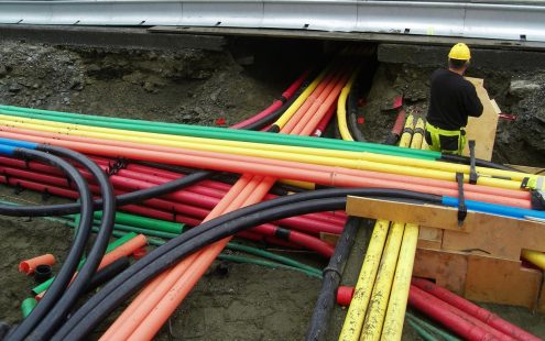 A large-scale duct bank is being installed in a busy urban area.